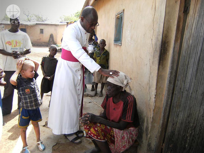 Bishop Ignace Bessi Dogbo blesses the old lady in Ivory Coast