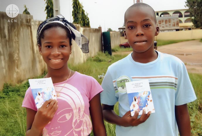 A girl and a boy - each with a copy of the Rosary booklet Children praying the Rosary in Fundamental French
