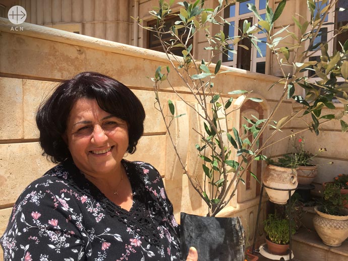 Rabah with her Olive tree received by ACN
