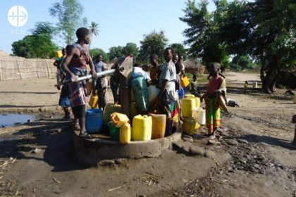 Women and children getting water at a water pump.