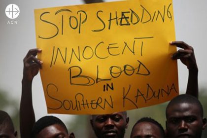 Men with handwritten posters demonstrate against the killing in Southern Kaduna.
