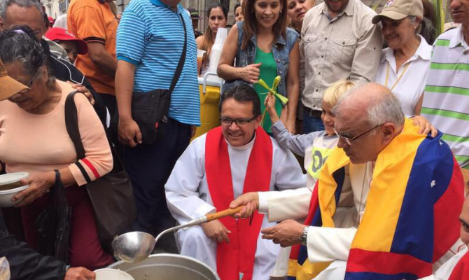 Cardinal Baltazar Porras sharing food with the poor people
