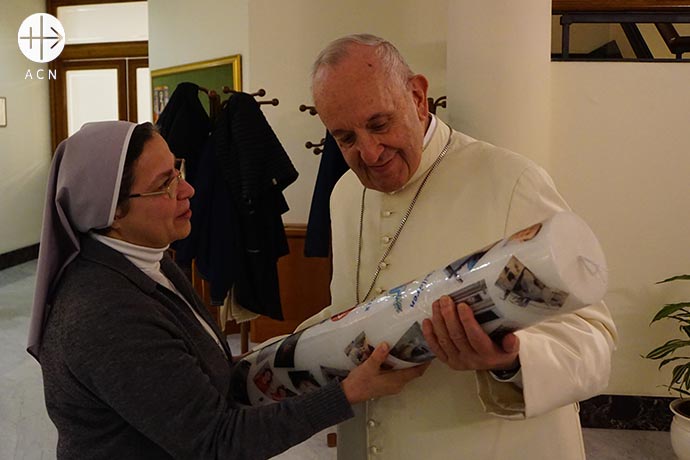 El Papa Francisco recibiendo un cirio de la campaña "Velas por la paz en Siria", de manos de la hermana Annie Demerjian, religiosa siria.
