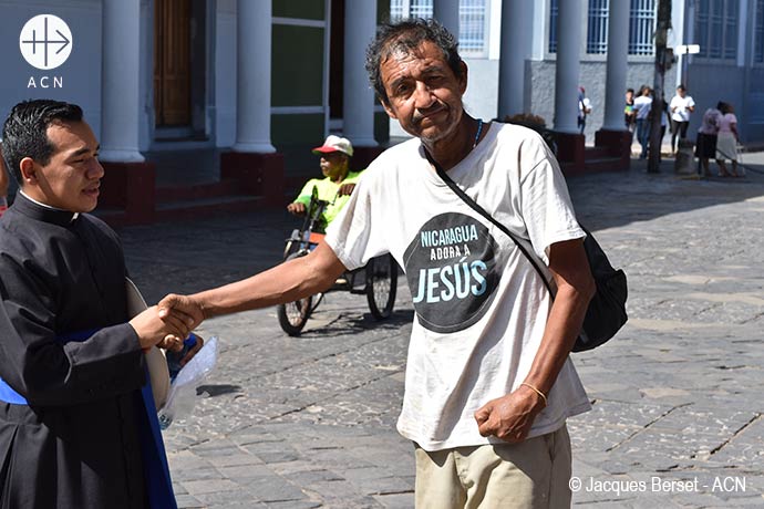  Mgr Jorge Solórzano Pérez, Bishop of Granada, during the distribution of a meal for the poor of the city - Poor man wearing a T-Shirt with the slogan "Nicaragua loves Jesus".