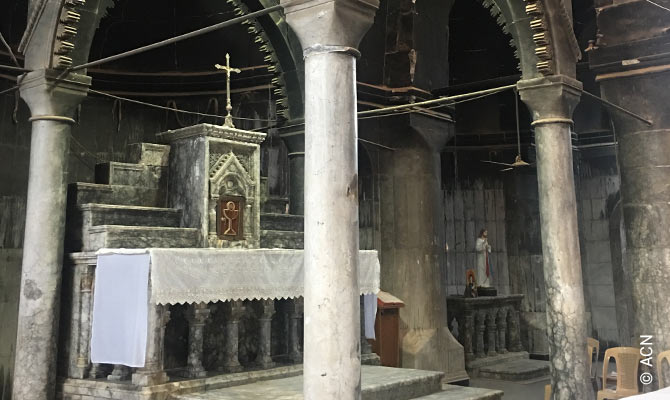 The Divine Liturgy in Al-Tahira Cathedral – the walls still blackened and partly open to the elements.