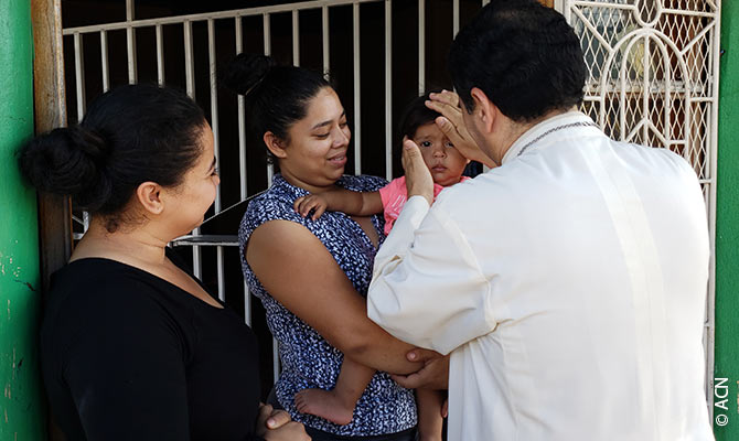 Derecha: el obispo de Matagalpa, Rolando José Álvarez Lagos, bendice a un niño.