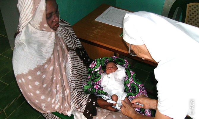 La hermana misionera Hilda, de la orden franciscana, en un hospital con un recién nacido.