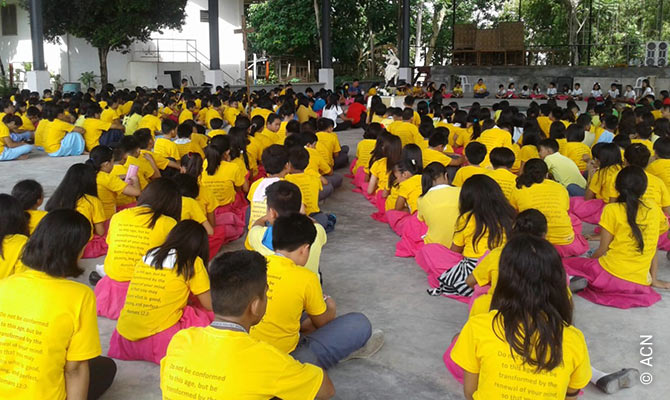 Schoolchildren in Tibungco, Davao City, praying the rosary.
