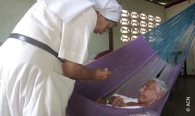 Un’anziana malata riceve la comunione a San Agustín.