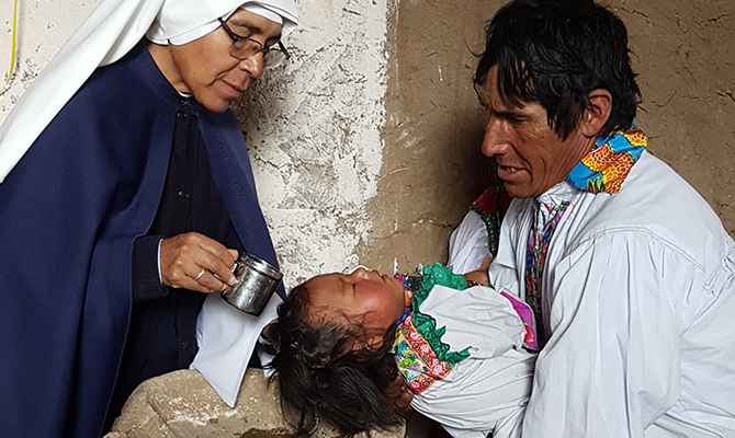 A missionary religious sister of the congre-gation “Misioneras de Jesús Verbo y Víctima” at a baptism in Sucre.