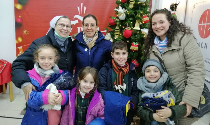 Monja católica distribuyendo chaquetas a familias