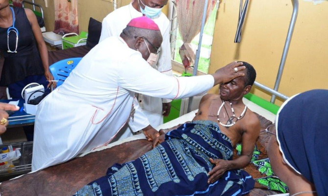 Bishop blesses a victim of the massacre in Nigeria