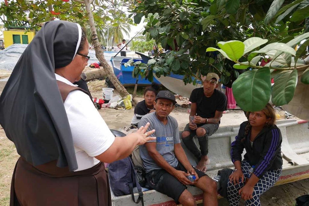 Sister Diana talking to migrant family