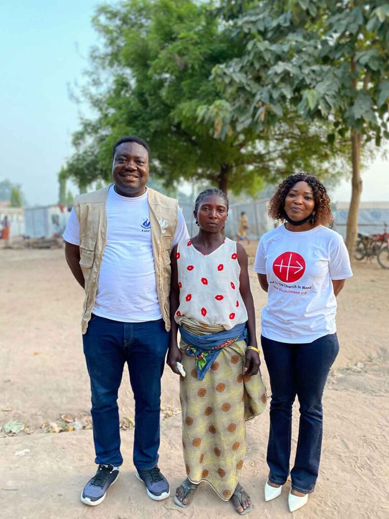 Pater Remigius Ihyula (Koordinator, Stiftung für Gerechtigkeit, Entwicklung und Frieden), Rosemary Udoji (eines der Opfer der bewaffneten Fulani-Hirten) und Patience Ibile in einem Flüchtlingslager in Guma.