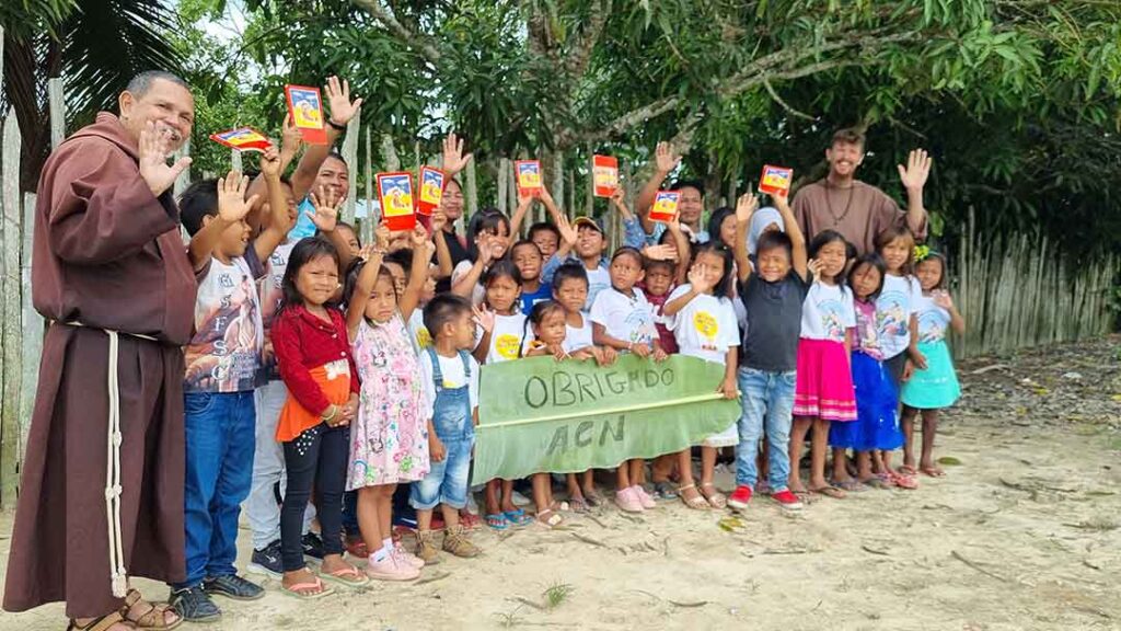 Des enfants indigènes Ticuna avec le frère Lourival et le frère Paolo Braghini remerciant l'AED pour le don de la Bible des enfants en langue Ticuna.