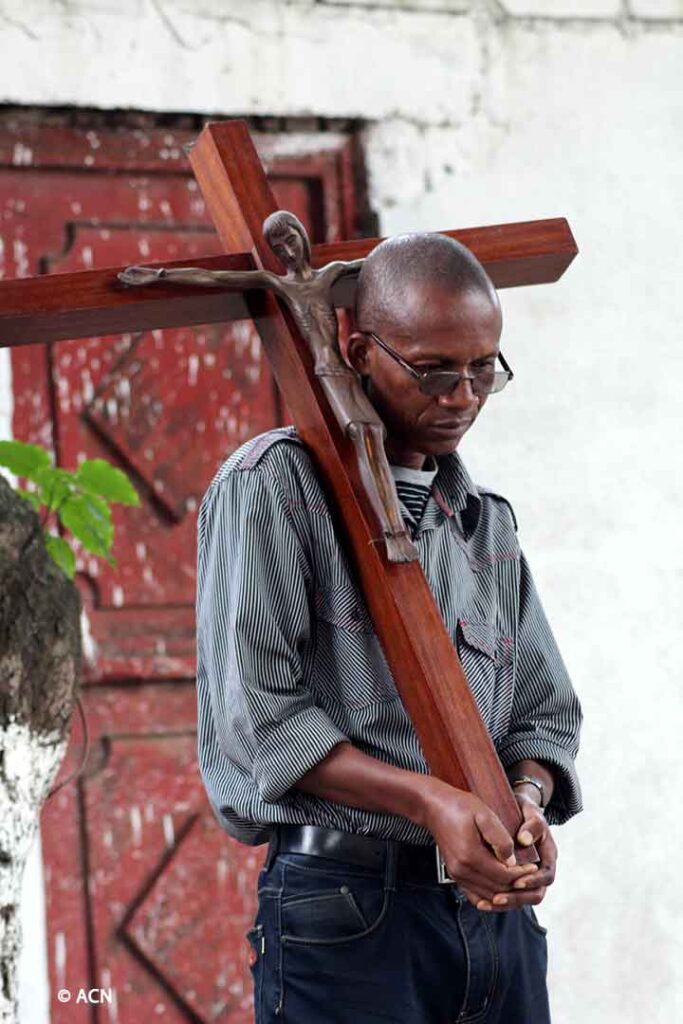 A Congolese man praying the way of the Cross.