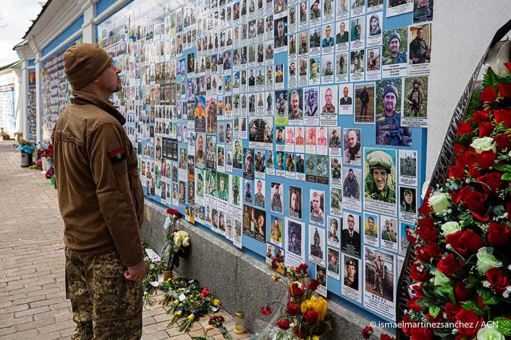 A soldier looks at the wall with photos of those who have fallen for Ukraine since the invasion of Crimea in 2014