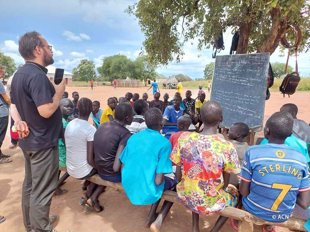 Mgr Christian Carlassare, Missionnaire Combonien, visite une école sous les arbres à la paroisse de la Sainte Croix, Yirol.