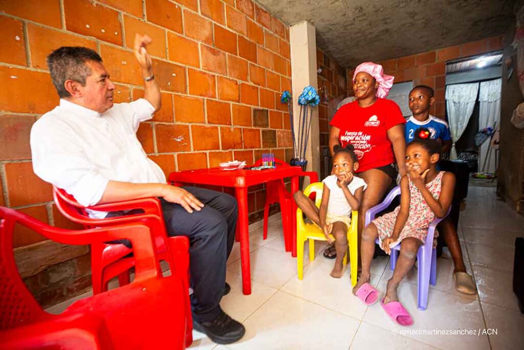 Father Gersaín Paz, parish priest of Santa Marta church, visiting a local family