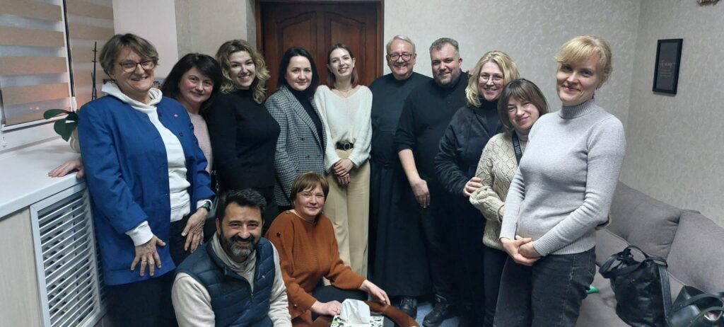 Pater Anton und Magda Kaczmarek an der Seite einer Gruppe von Frauen, die einen Ehemann oder einen Sohn oder beides im Krieg in der Ukraine verloren haben