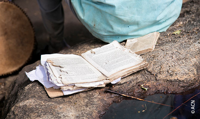 Old prayer book at Mass in the Palabek refugee camp.