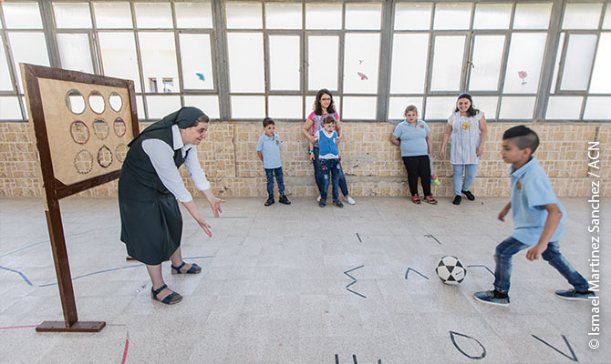 Sister Samia of the Sisters of the Sacred Hearts of Jesus and Mary in Homs playing football with one of the children of “Le Sénevé”, a centre that cares for 80 children with disabilities or autism..