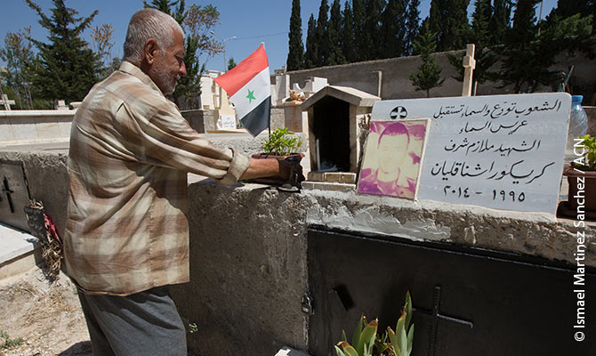 The father of the martyr Makar Makar visits the grave of the martyr Krikor Ashnagelian at the Syrian-Armenian cemetery in Aleppo.